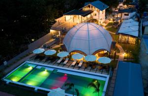 Draufsicht auf einen Pool mit Sonnenschirmen und einem Gebäude in der Unterkunft Fizz Diving Resort in Panglao