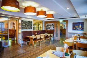 a restaurant with wooden tables and chairs and lights at Zum Simonbräu in Bitburg