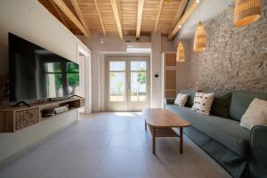 a living room with a blue couch and a table at Meraki Villa Pelion in Kalamos
