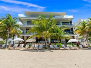 a hotel on the beach with chairs and palm trees at La Sirène in Simpson Bay