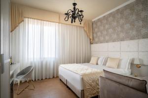 a bedroom with a large bed and a chandelier at Re Enzo in Bologna