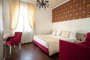 a bedroom with a large bed and a red chair at Re Enzo in Bologna