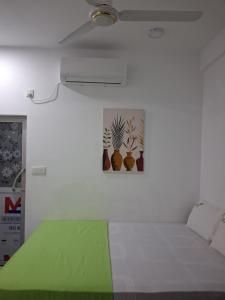 a bedroom with a bed with a green blanket at Beach Life Long Beach Resort in Trincomalee