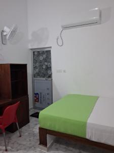 a bedroom with a green bed and a red chair at Beach Life Long Beach Resort in Trincomalee +82 photos