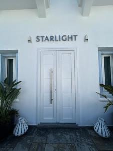 a white door with the wordsstart gmaxwell above it at Starlight Luxury Studios in Mikonos