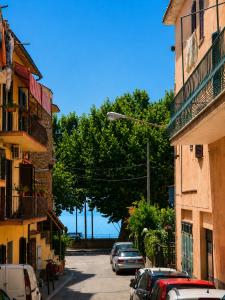 a street with cars parked on the street between two buildings at Le Bonbon in Trevignano Romano
