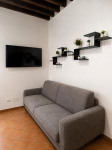 a couch sitting in a living room with a tv at Le Bonbon in Trevignano Romano