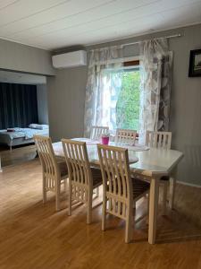 a dining room with a white table and chairs at Wooden House 2 bedrooms in Turku