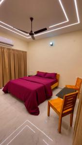 a bedroom with a large bed with a red blanket at Seabreeze Village Resort and Restaurant in Gokarn