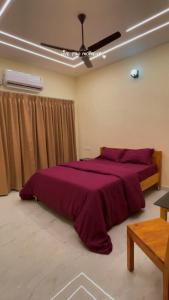 a bedroom with a large purple bed with a ceiling fan at Seabreeze Village Resort and Restaurant in Gokarn +17 photos