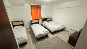 a small room with two beds and a window at METRO Hotel in Gusinje