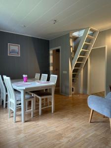 a dining room with a table and chairs and a staircase at Wooden House 2 bedrooms in Turku +9 photos