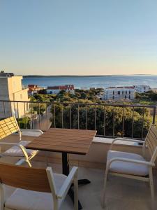 a balcony with a table and chairs and the ocean at Apartments DiVi Sunset View in Mandre