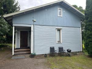 a small blue house with two chairs and a door at Wooden House 2 bedrooms in Turku