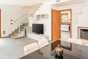 a living room with a tv and a staircase at Villa Sonia in Bardolino