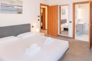 a bedroom with two white beds and a bathroom at Villa Sonia in Bardolino