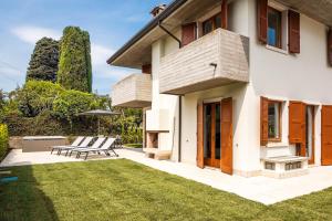 a house with a patio and a lawn at Villa Sonia in Bardolino