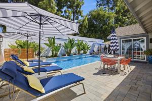 a pool with blue lounge chairs and an umbrella at Laguna oasis Pool, Jacuzzi, Sauna in Laguna Hills