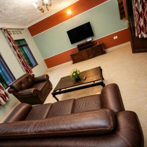a living room with a leather couch and a table at Kivu Go-Lax Resort in Gisenyi