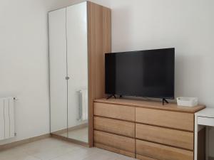 a flat screen tv sitting on top of a wooden dresser at Albizi Home in Pontassieve
