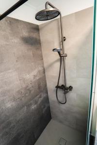 a shower with a shower head in a bathroom at Horizont Hillside Mályinka in Mályinka