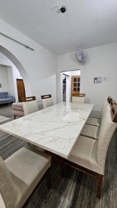 a dining room with a large white table and chairs at Marwa in Kannur