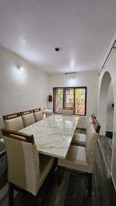 a dining room with a large marble table and chairs at Marwa in Kannur +22 photos