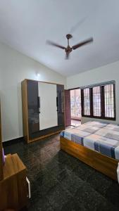 a bedroom with a bed and a ceiling fan at Marwa in Kannur