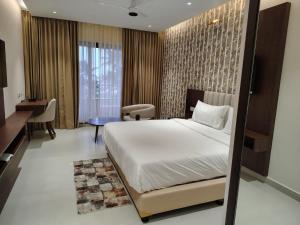 ein Hotelzimmer mit Bett und Schreibtisch in der Unterkunft Tidal Crest in Kundapura