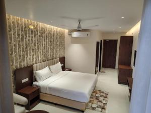 ein Schlafzimmer mit einem weißen Bett in einem Zimmer in der Unterkunft Tidal Crest in Kundapura + 9 Fotos