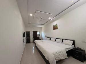 a bedroom with a large bed with white sheets at Hotel A3cube in Panna