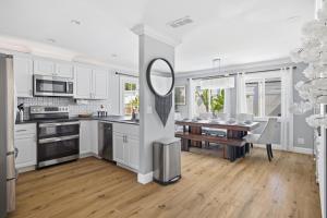 a kitchen with white cabinets and a table with a mirror at Laguna oasis Pool, Jacuzzi, Sauna in Laguna Hills