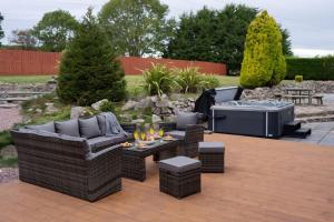 a patio with wicker furniture and a barbecue grill at Woodside Barn in Newmacher