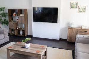 a living room with a table and a flat screen tv at Woodside Barn in Newmacher +57 photos