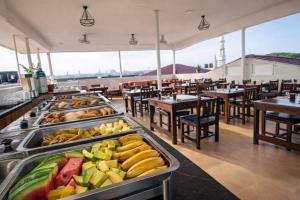 a buffet line with many trays of food in a restaurant at Golden Nap hostel in Zanzibar City