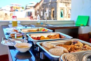 a buffet with several trays of food on a table at Golden Nap hostel in Zanzibar City +41 photos