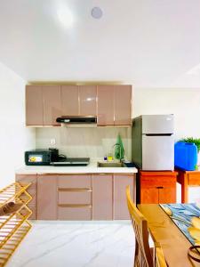 a kitchen with brown cabinets and a table with a tableablish at Unit 8F-34 Megatower Residences 3 in Baguio