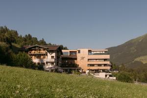 a large building on a hill with a green field at Hotel Marten -Joker Card Partner- in Saalbach-Hinterglemm +84 photos