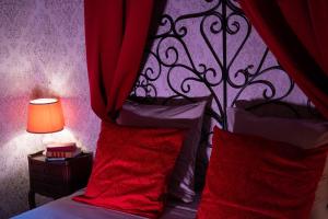 a bedroom with a bed with red pillows and a canopy at La Suite Magique du Sorcier in Nîmes