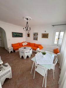 a living room with an orange couch and tables at Appartement à Miramar in Martil