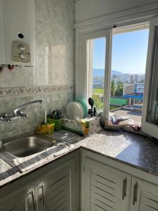 a kitchen counter with a sink and a window at Appartement à Miramar in Martil +6 photos