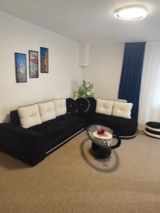 a living room with a black couch and a table at La Daniela in Făgăraş +2 photos