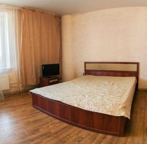 um quarto com uma cama e uma televisão de ecrã plano em Apartment-Studio in City centre on 50 Let VLKSM 13 em Tyumen