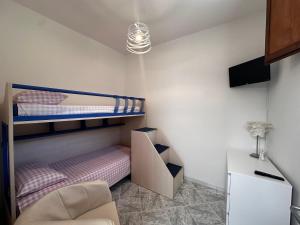 a bedroom with two bunk beds and a chair at Tenuta Moffa in Tramonti