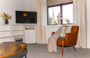 a living room with a table and a chair at Beach House in Thurso +27 photos