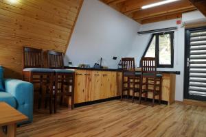 a kitchen with wooden floors and a bar with stools at Andrei's Refugium in Ocnele Mari