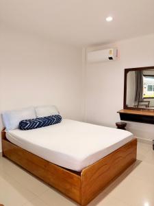 a bed in a room with a mirror and a bed sidx sidx sidx at ฤทัยลอดจ์ in Ban Tao Than