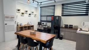 a kitchen with a wooden table and black chairs at 台東靜巷19號民宿編號1901 in Taitung City