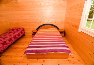 Habitación pequeña con 1 cama en una cabaña de madera en Atostogų nameliai Karklės kopos, en Karklė