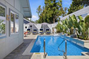 a swimming pool with chairs and plants next to a house at Laguna oasis Pool, Jacuzzi, Sauna in Laguna Hills